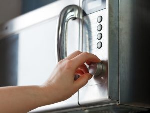 a person turning off a microwave because of overheating