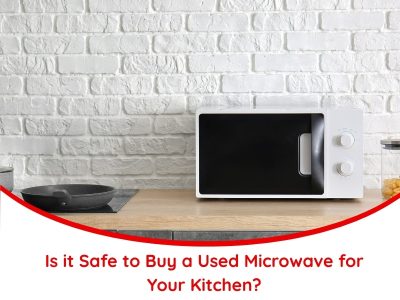 Modern kitchen countertop with a white microwave oven, illustrating the concept of buying a used microwave and evaluating its safety for home use.